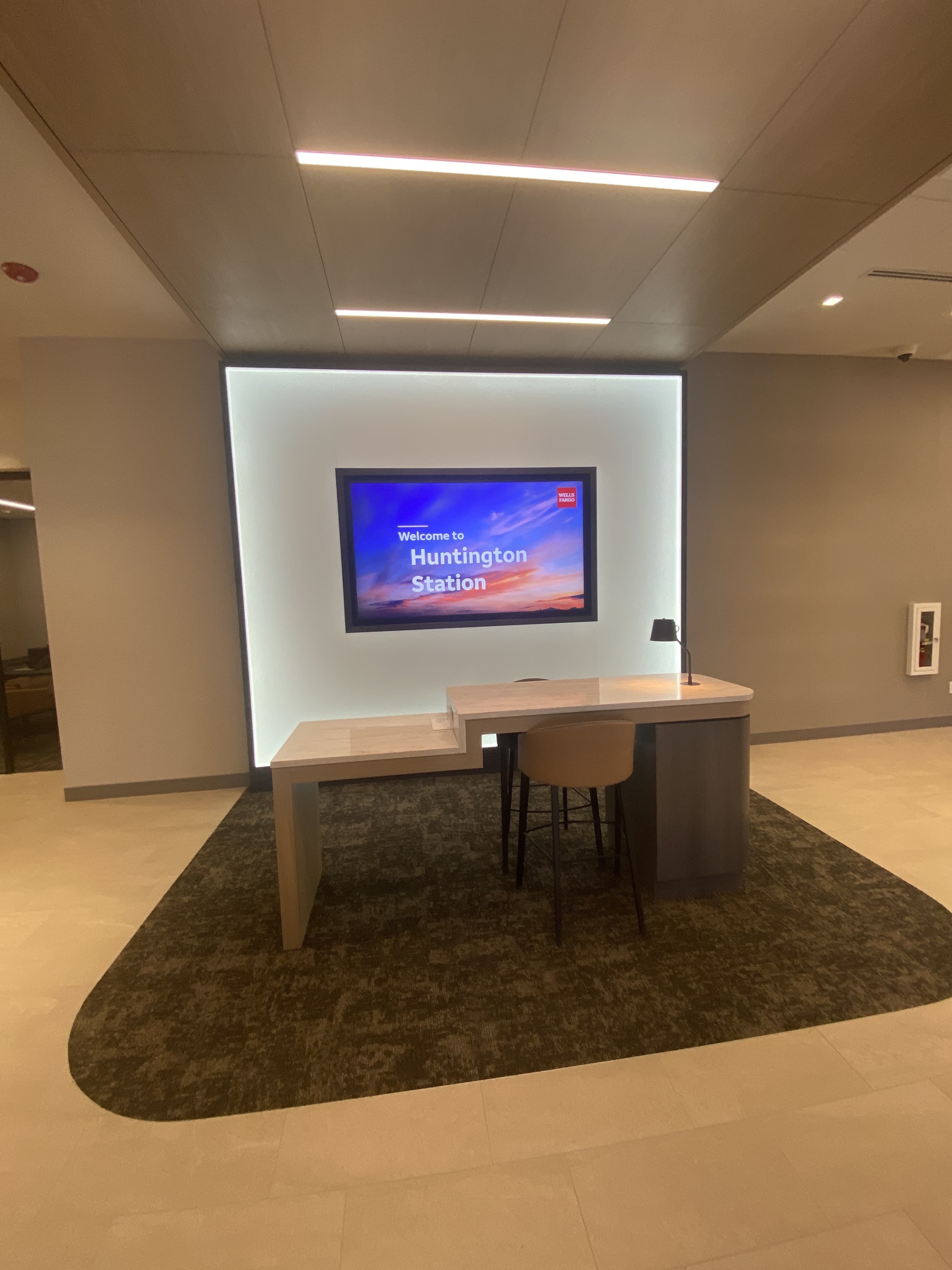 Finished bank welcome desk with a backlit feature wall built by Deerfield Interiors, New York City