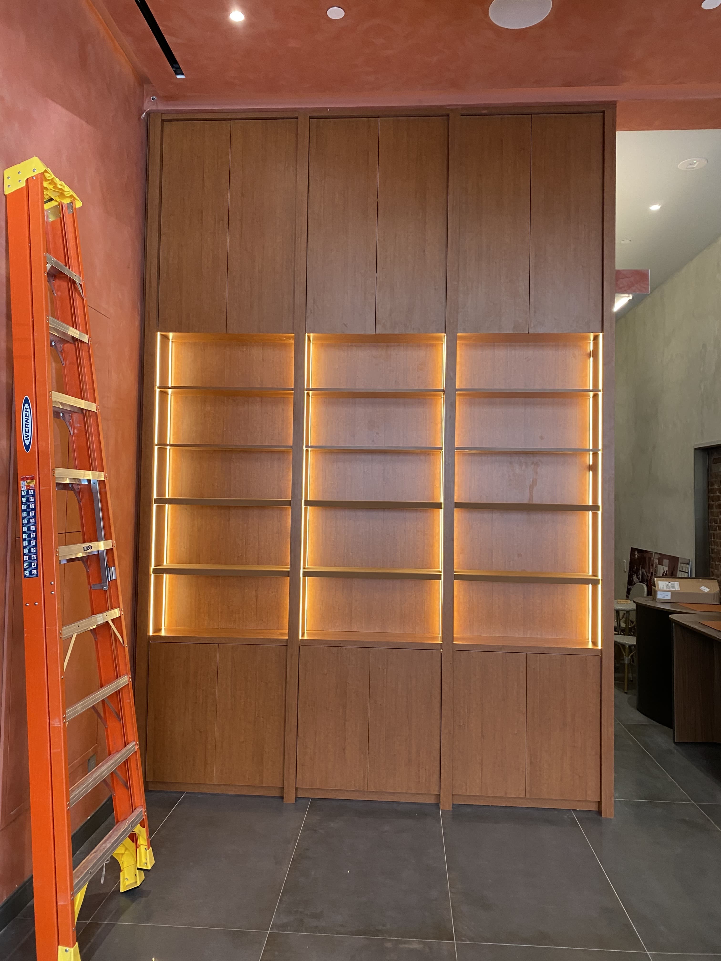 Warm wood-veneer slat paneling being installed by Deerfield Interiors in New York City