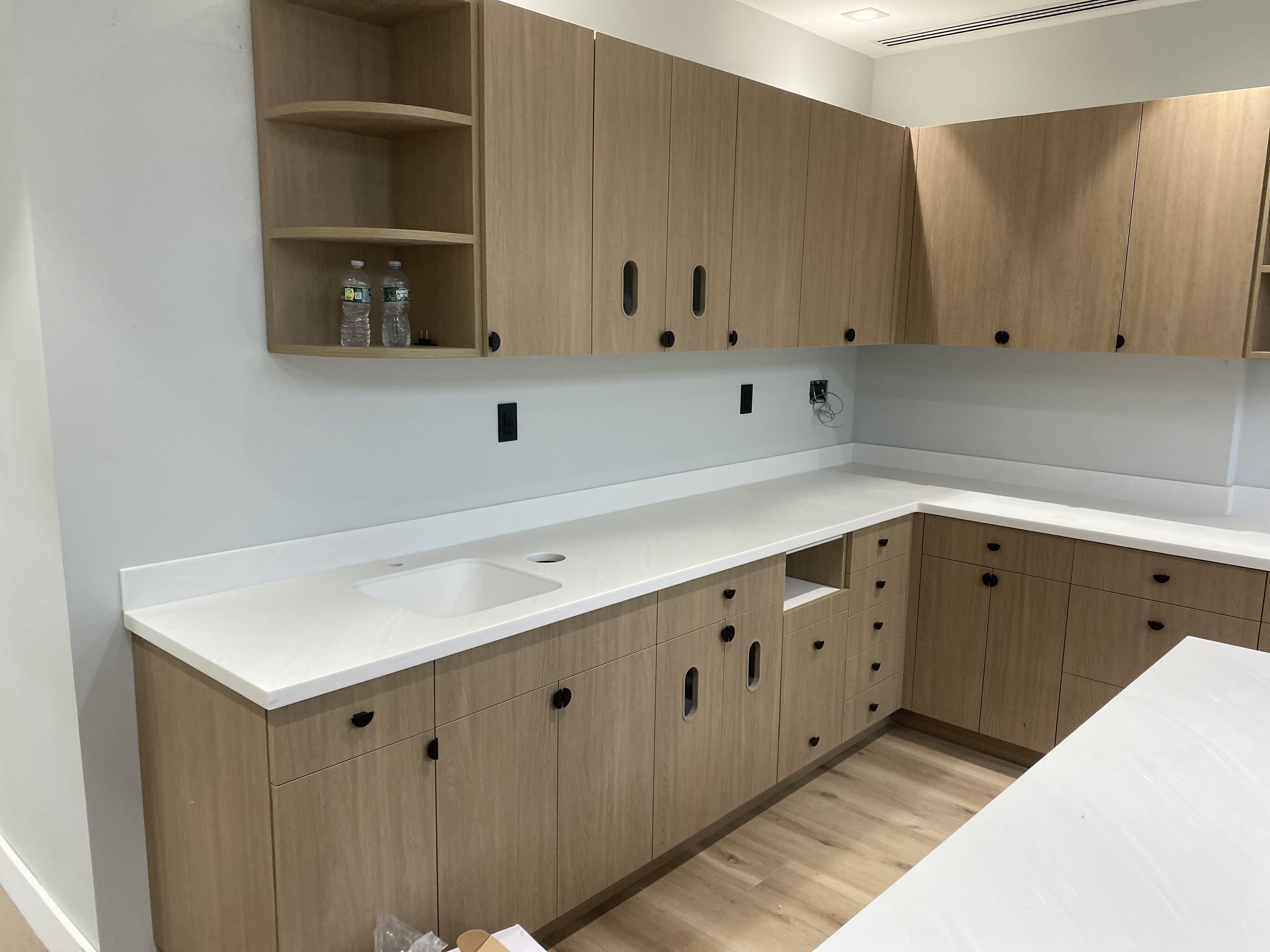 Finished dental exam room with warm wood casework and integrated sink by Deerfield Interiors