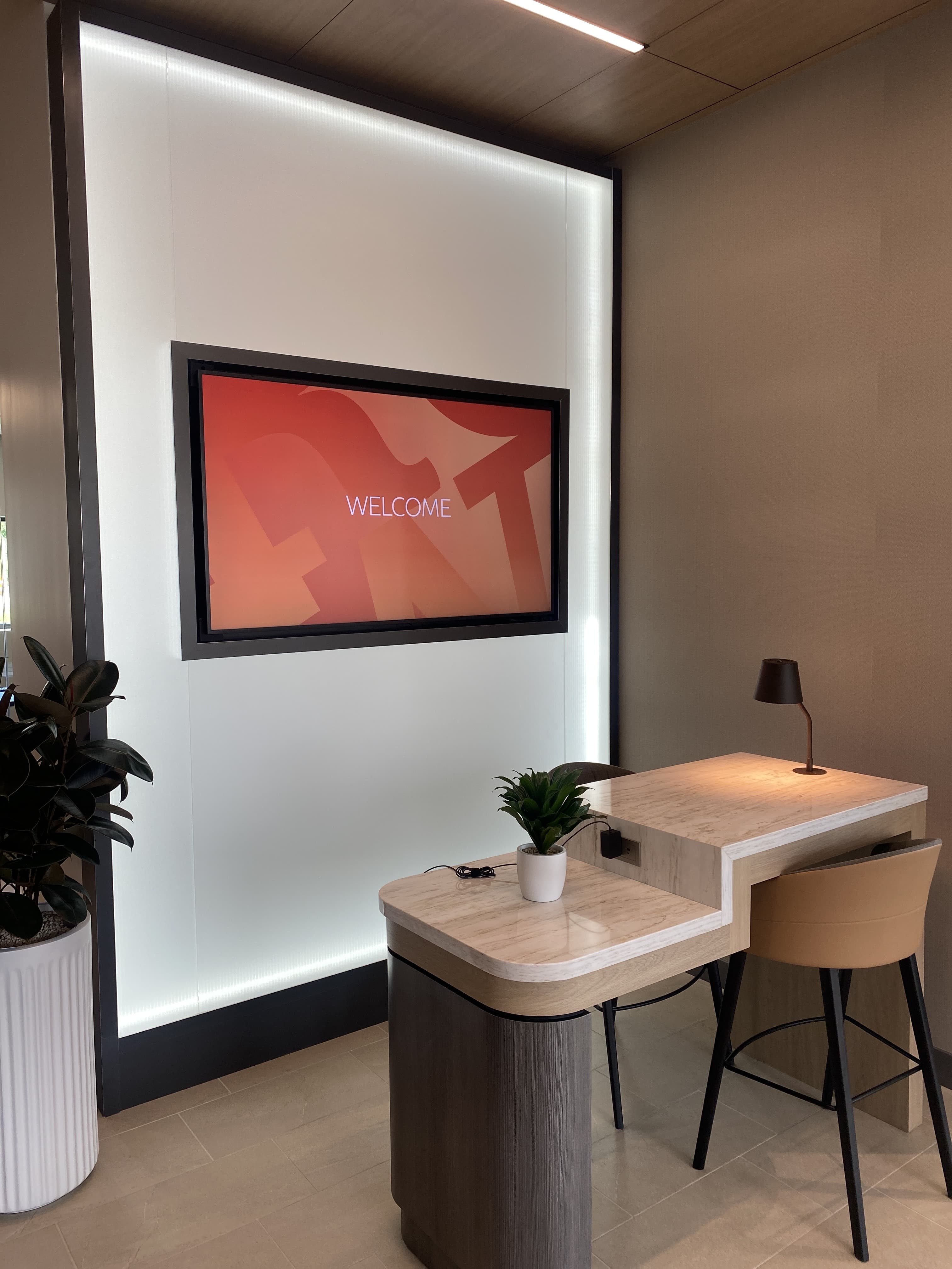 Polished welcome nook with backlit panel wall and custom duo desk by Deerfield Interiors