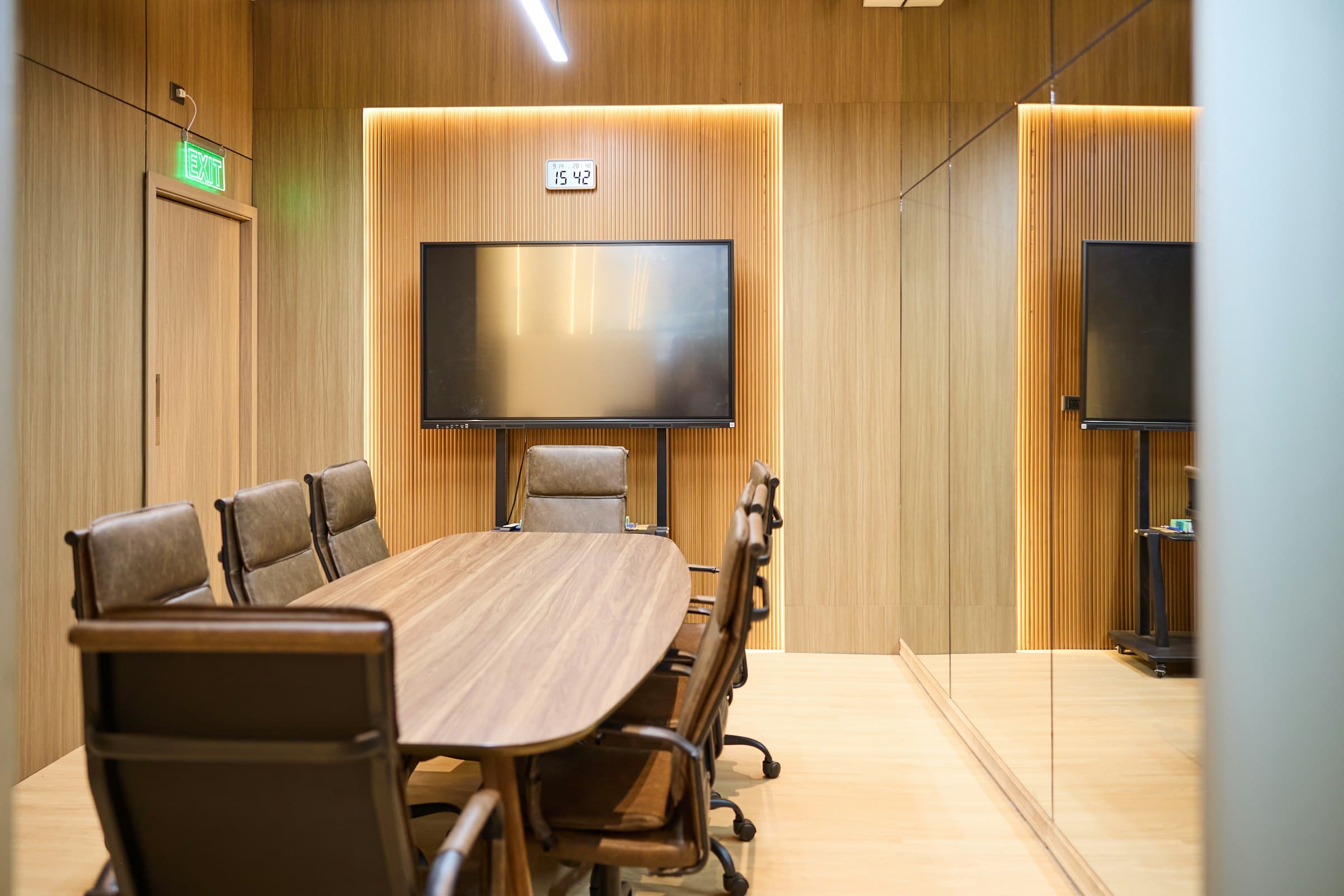 Warm wood-paneled executive conference room with custom veneer table